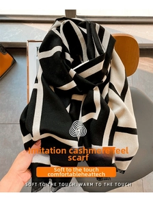 Detail of soft geometric cashmere-like scarf with black and white check and tassel edge