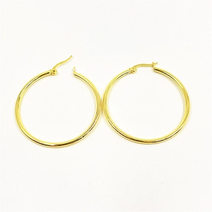 Detail view of large gold-plated round hoop earrings with polished smooth finish