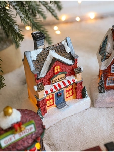 Close-up of resin Christmas Toy Lane and Gift Shop miniature houses with LED lights