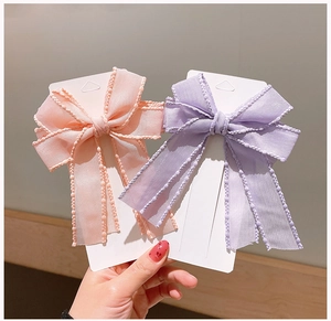 Close-up of pink and purple mesh bow hair clips with delicate beaded edge detailing