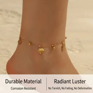 Detail of gold-plated turtle and dolphin anklet worn on the beach with sea shell pendants