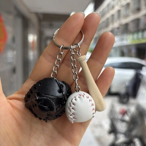 Detail of baseball keychain with mini leather glove, wooden bat, and white ball pendant