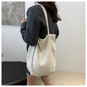 Detail view of large cream canvas tote bag with thick cotton rope shoulder straps