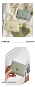 Detail of mint green and cream women's short wallet with gold butterfly hardware decoration