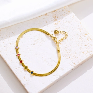 Detailed shot of golden snake chain bracelet featuring five vibrant colorful square zircons