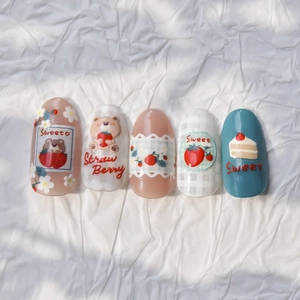 Detailed view of 3D embossed dog and strawberry nail art stickers with plaid patterns