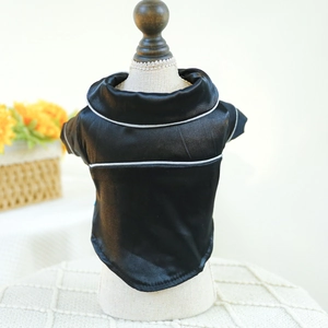 Detail of black satin pet pajamas with white piping displayed on a mannequin