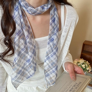 Detail view showing the texture of the pastoral plaid mesh scarf worn as a necklace