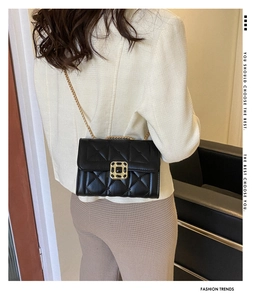 Classic black quilted crossbody bag with gold chain strap worn by a model