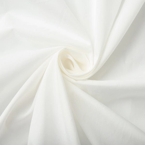 Détail macro du tissu en coton blanc montrant la texture tissée et les plis en spirale