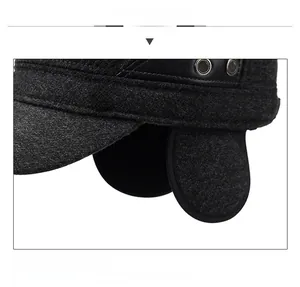 Detailed view of dark grey wool winter cap featuring thick earflaps and metallic R badge