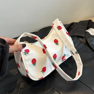 White nylon handbag with red strawberry prints and a single handle shown in a side view