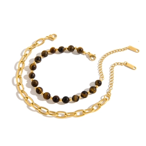 Detailed macro view of gold-tone stainless steel chain and natural tiger eye bead bracelets