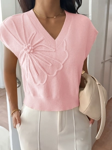 Close-up of pink knit vest featuring 3D floral embroidery and deep V-neckline