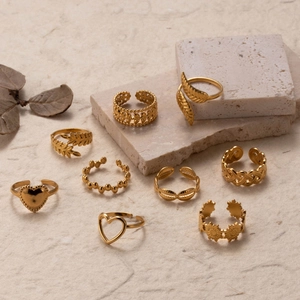 Set of 9 adjustable golden stainless steel rings with leaf and heart designs on stone