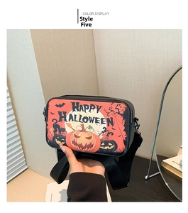 Detail view of Halloween crossbody bag with orange pumpkin print and black nylon strap