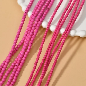 Macro shot of bright pink turquoise spacer beads on white wavy ceramic plate