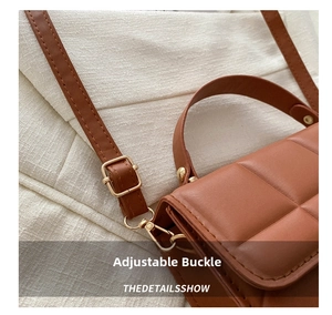Detail of adjustable gold buckle and quilted texture on a brown crossbody bag