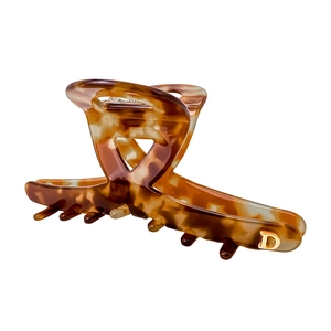Détail macro d'une pince à cheveux écaille de tortue avec décoration initiale D dorée