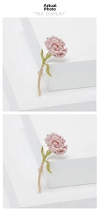 Detail of pink carnation brooch with enamel finish and green leaves on white stand