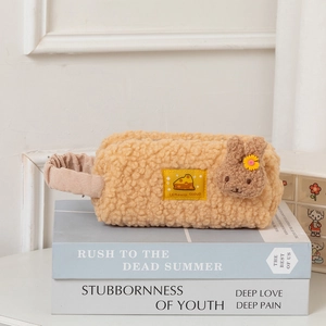Detail of orange plush pencil case with cute rabbit and cheese decoration and handle
