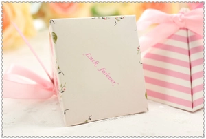 Macro shot of pyramid pink floral candy box with silk ribbon and Luck forever text