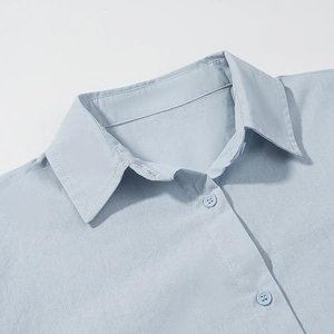 Detail view of the light blue shirt collar with classic lapel and matching buttons