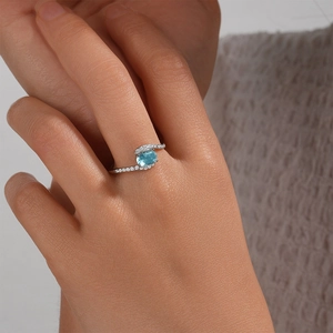 Macro detail of silver S925 ring with oval blue gemstone and white zircon accents