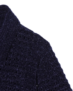 Dettaglio ravvicinato della giacca in maglia blu scuro con frange e trama del tessuto