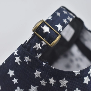 Close-up of a navy cotton baseball cap showing silver star prints and antique metal buckle