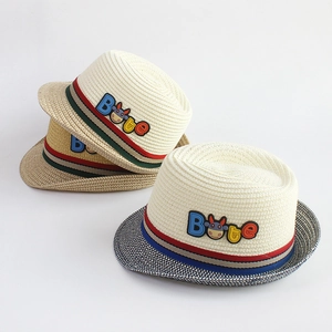 Detail of children's straw fedora with colorful ribbon and cartoon cow rubber patch