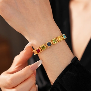 Détail macro du bracelet vintage doré orné de zircons carrés colorés scintillants