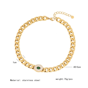 Macro detail of 1cm gold cuban link necklace with green oval stone and size specs