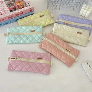 Detailed view of quilted candy color pencil cases in various pastel shades for stationery