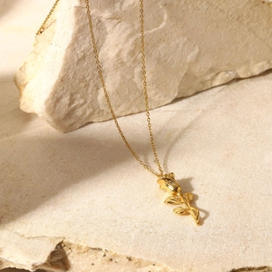 Détail du pendentif rose 3D plaqué or 18K sur un fond en pierre naturelle élégante