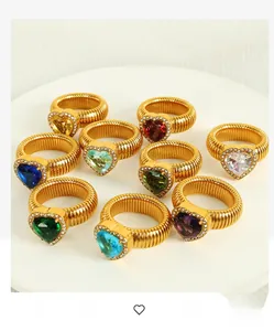 Close-up of gold heart rings with colorful gemstones and ribbed spiral bands