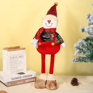 Detailed view of plush Christmas snowman doll with retractable legs on festive table