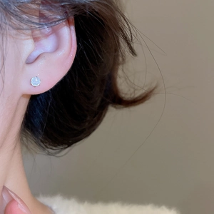 Close-up of elegant silver zircon stud earring worn by a model for a refined look