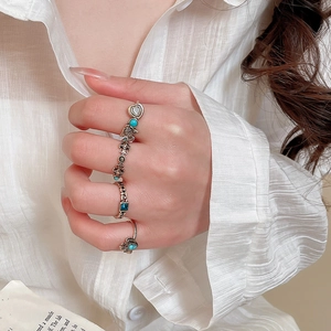 Close-up of vintage resin rings with rhinestone accents on fingers in natural light