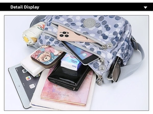 Spacious interior of purple polka dot nylon shoulder bag showing various storage compartments