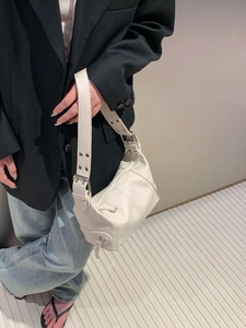 Close-up of cream PU leather baguette bag with silver zipper and wide shoulder strap