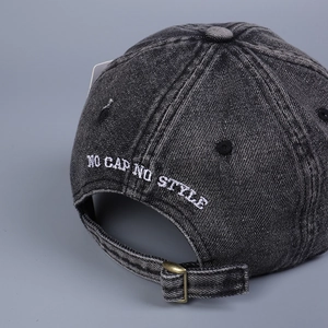 Detail of adjustable metal buckle and 'NO CAP NO STYLE' embroidery on washed denim hat