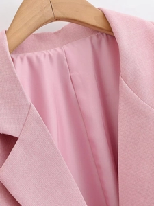Detail of pink blazer collar with fine fabric texture and smooth satin lining
