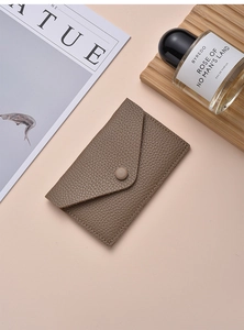 Detailed view of taupe litchi grain leather card holder with snap button closure