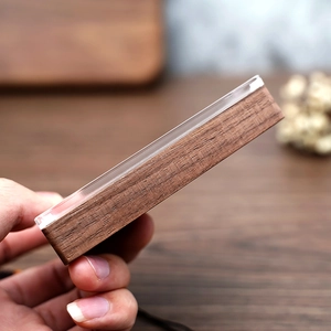 Detail of the walnut wood base and thick acrylic cover on a portable jewelry box
