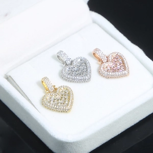 Macro shot of heart-shaped zircon pendants in silver, gold, and rose gold plating