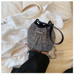Detailed view of a mini black rhinestone bucket bag with shiny crystals and silver chain