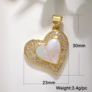Macro detail of a 30mm gold heart pendant with shell inlay and cubic zirconia crystals