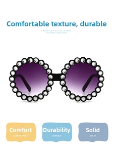 Detail of round children's sunglasses featuring a rhinestone-studded frame and gradient lenses