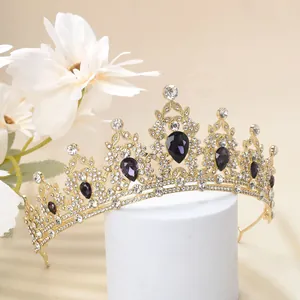 Close-up of gold crown with sparkling rhinestones and purple teardrop crystals
